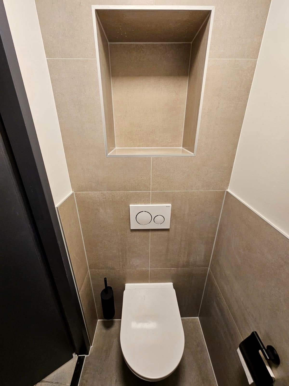 Zwevend toilet met een verdiepte nis erboven en een witte bedieningsplaat